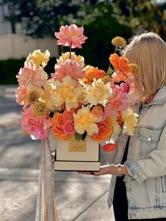 a woman standing next to a bunch of flowers