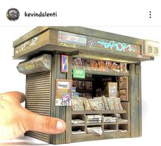 a hand is pointing at a small toy vending machine