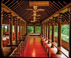 the inside of a restaurant with red carpet and wooden tables on either side of it