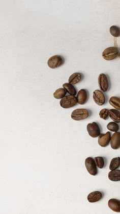 some coffee beans are on a white surface