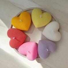 four heart shaped candles sitting on top of a white plate