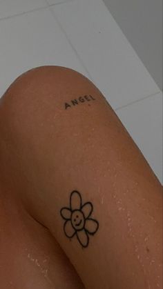 a close up of a person's legs with a flower tattoo on their leg