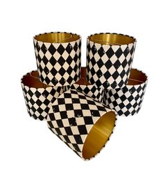 four black and white checkered paper cups with gold rims on each one side