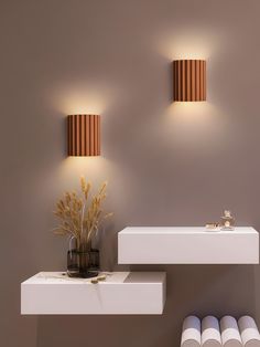 a bathroom with two lights on the wall and one light on the shelf next to it