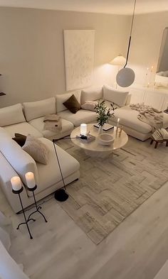 a living room filled with white furniture and candles