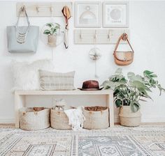 a room filled with lots of baskets and plants on top of a rug next to a wall