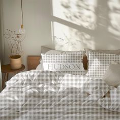 an unmade bed with white and black checkered sheets, pillows and pillowcases