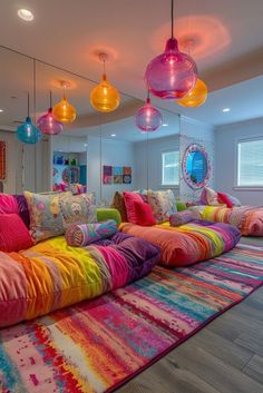 a living room filled with lots of colorful pillows and lights hanging from the ceiling above