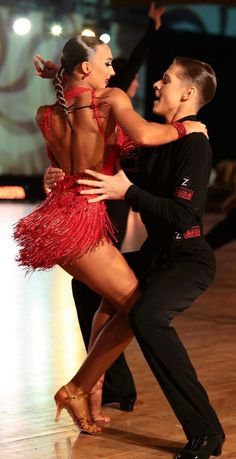 a man and woman dancing on the dance floor