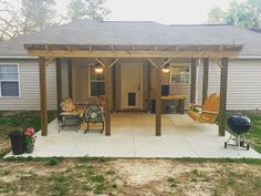 a covered patio with chairs and bbq