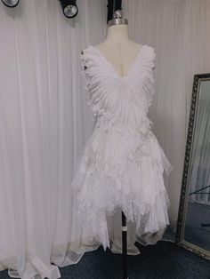 a white dress on display in front of a mirror