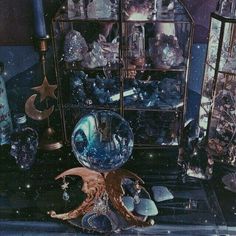 an assortment of glass and crystal items on display in a room with lights, candles and ornaments