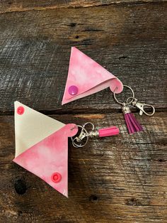 two pink and white triangle shaped key chains