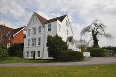 a large white house sitting on top of a lush green field