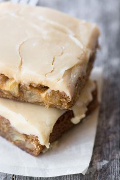 two pieces of cake sitting on top of each other with frosted icing over them