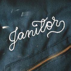 the name janitor written in white ink on a blue jean jacket with zippers