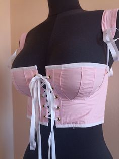 This corset is directly inspired by regency clothes and will be perfect for History bounding or historical reproduction. Daphne has a front opening as well as adjustable and removable straps for more comfort. This corset is made of pink cotton lined with white cotton. It is adorned with white satin ribbons, and stiffened with synthetic whalebone. This pair of stays will fit the measurements Waist 69cm (27in), Bust 85cm (33in). This color combination is also available for measurements Waist 61cm, Regency Short Stays, Regency Corset, History Bounding, Pink Corset Top, Short Stays, Costume Inspo, Pink Corset, Satin Ribbons, Regency Era