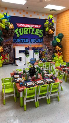 the teenage mutant ninja turtles birthday party is set up with green and white tables, chairs, and decorations