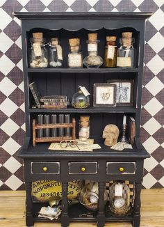 an old fashioned black bookcase with lots of stuff on it's top shelf