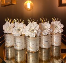 four jars with flowers in them sitting on a table