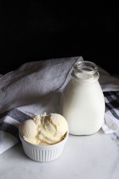 a bowl of ice cream next to a bottle of milk