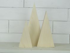 two wooden christmas trees sitting on top of a shelf