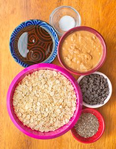 bowls filled with oatmeal, peanut butter and chocolate chips on a wooden table