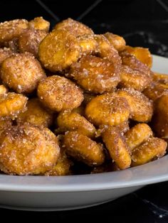 a white bowl filled with fried food on top of a table next to a black counter