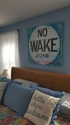 there is a bed with pillows on it and a no wake sign above the headboard