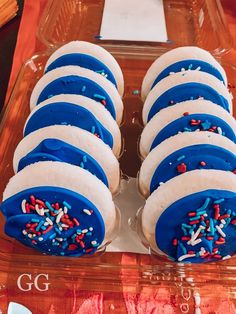 blue and white cupcakes with sprinkles in a plastic container