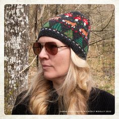 a woman wearing sunglasses and a knitted hat in front of a tree with the text fox in the forest hat