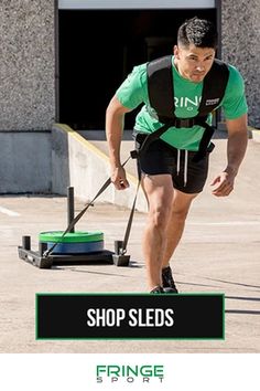 a man with a green shirt and black shorts is using a mop