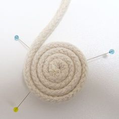 a white piece of yarn with pins attached to it