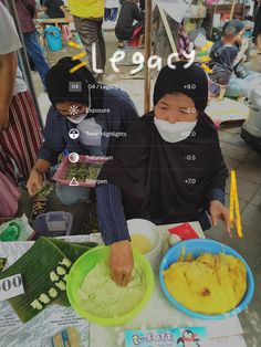 two people sitting at a table covered in food