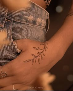 a close up of a person's arm with a flower tattoo on the wrist