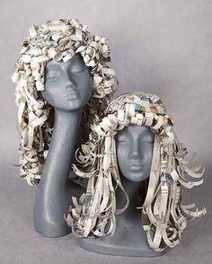 two mannequin heads made out of newspaper strips and paper machs, one wearing a headdress