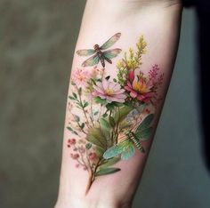 a woman's arm with flowers and dragonflys on the left side of her arm