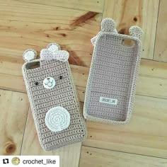 two crocheted cell phones sitting on top of a wooden floor next to each other