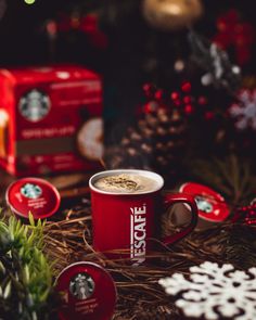 there is a cup of coffee on the table next to some cookies and other decorations