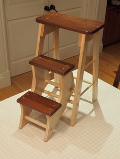 a wooden step stool sitting on top of a hard wood floor