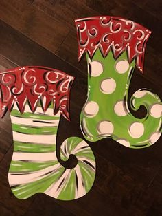 two painted christmas stockings sitting on top of a wooden floor