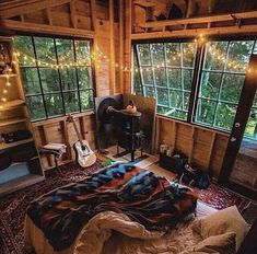 the bedroom is decorated with string lights and blankets on the bedspread, along with an electric guitar