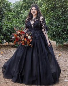 a woman in a black dress with flowers on her head and an orange bouquet behind her