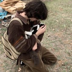 a person sitting on the ground holding a cat