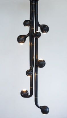 a black metal light fixture with five lights on each side and one hanging from the ceiling