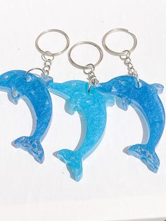 two blue dolphins keychains sitting on top of a white table