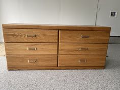 a large wooden dresser sitting on top of a white carpeted floor next to a wall