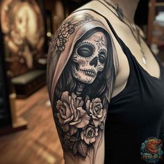 a woman with a skull and roses tattoo on her arm