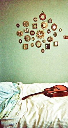 a guitar laying on top of a white bed