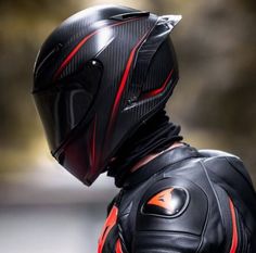 a man wearing a black and red leather suit with a motorcycle helmet on his head